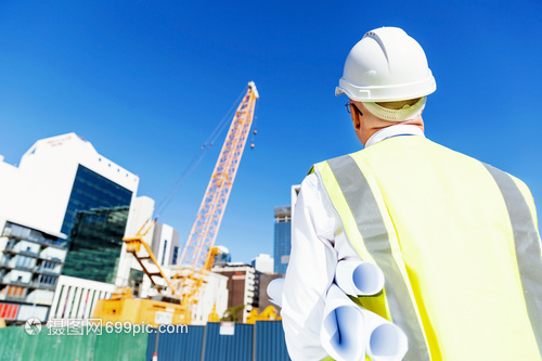 建筑工地的工程師建設(shè)者工程師建筑工人施工場(chǎng)景穿著帶藍(lán)圖的安全背心